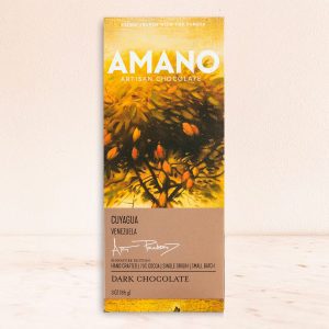 Chocolate bar packaging features a vibrant design with yellow and orange foliage, labeled "Amano Artisan Chocolate, Cuyagua, Venezuela, Dark Chocolate."