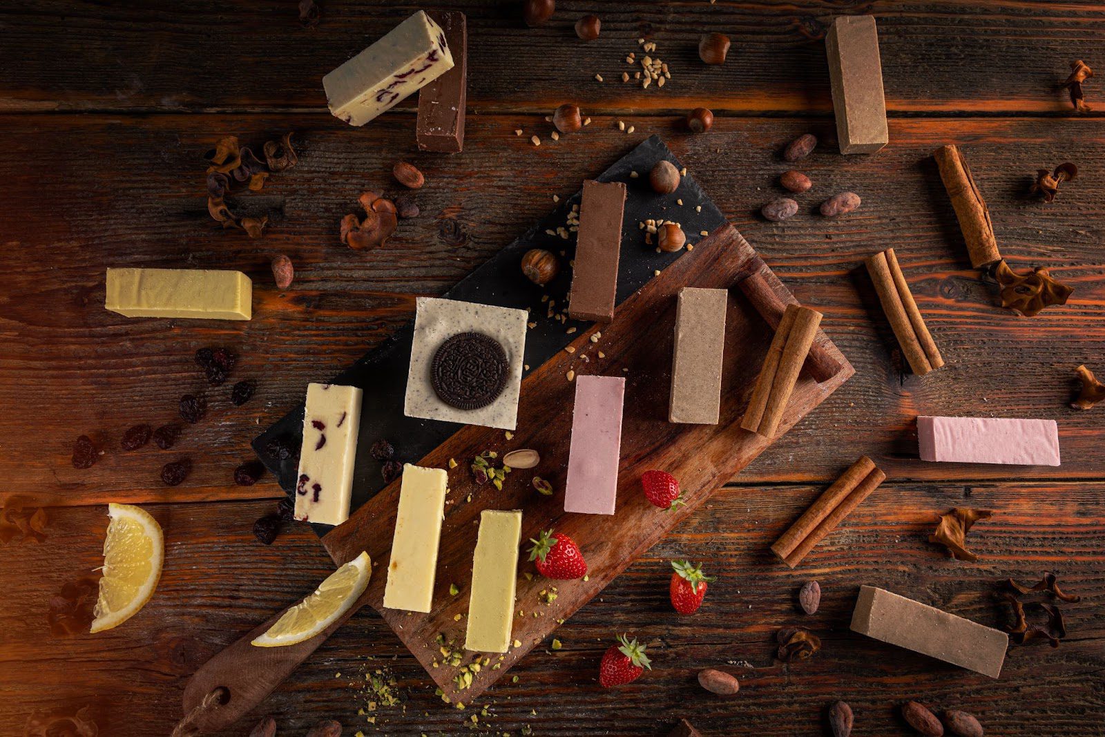 Assorted desserts with chocolate, strawberries, and nuts on a wooden table.