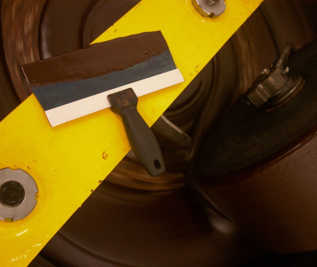 A yellow and black tool is positioned atop a yellow wheel highlighting its construction and purpose