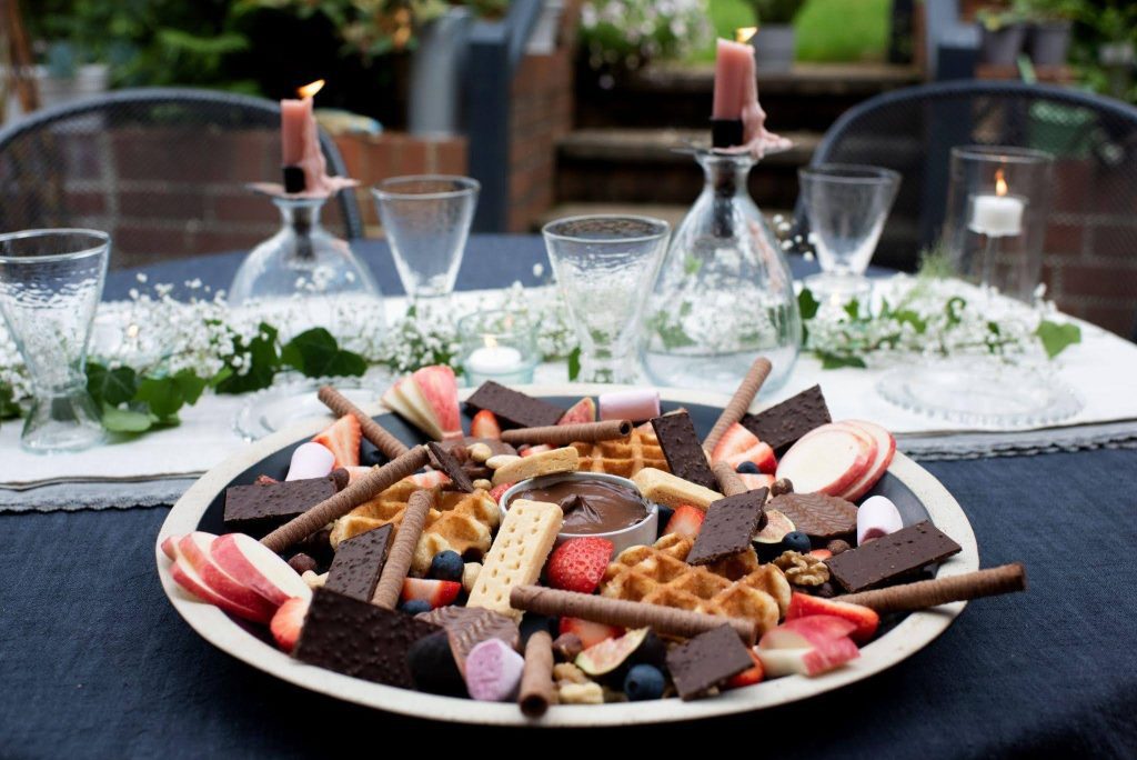A plate of colorful food including vegetables grains and protein arranged neatly on a wooden table